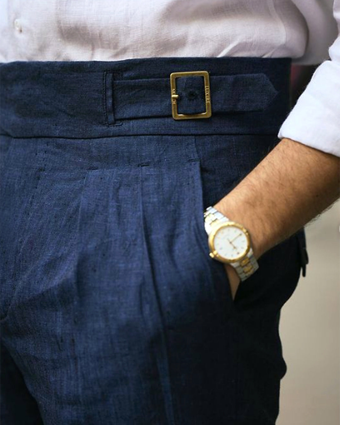 Male model wearing custom linen Gurkha pants for men by Luxire in dark indigo wearing a watch