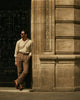 Model wearing the custom oxford polo shirt for men by Luxire in heather cream hands in pockets 3