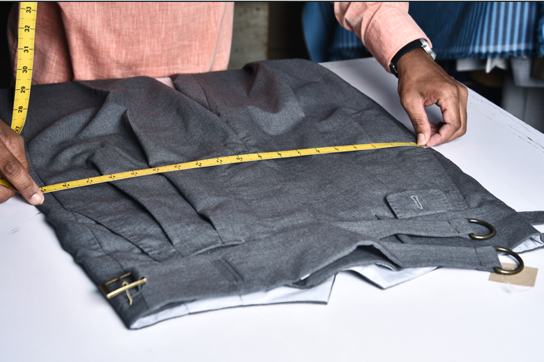 Craftsman measuring a garment at Luxire workshop